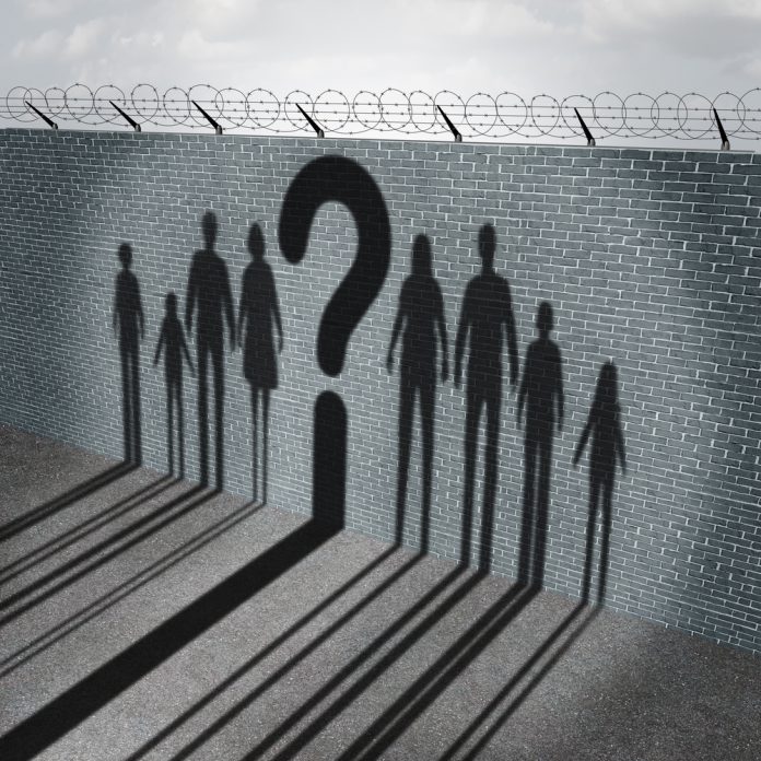 Immigration,Crisis,As,Foreign,People,On,A,Border,Wall,With mülteci karşıtlığı