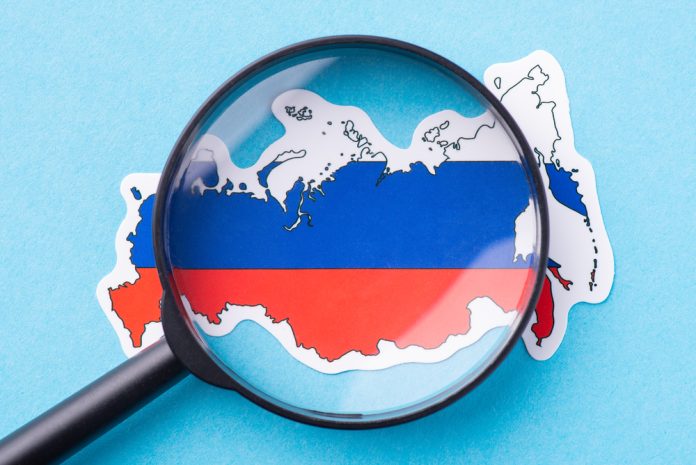 Magnifying,Glass,On,The,Map,Of,Russia.,Studying,Russian,Federation,